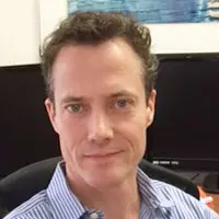 Headshot of a dark-haired businessman smiling